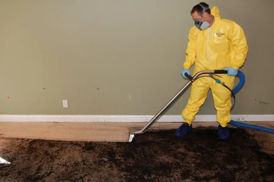 A technician in protective gear extracting a sewage backup in a Laguna Hills, CA home